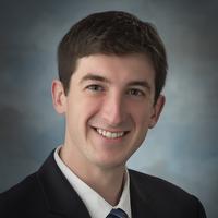 Man with brown hair smiling at camera