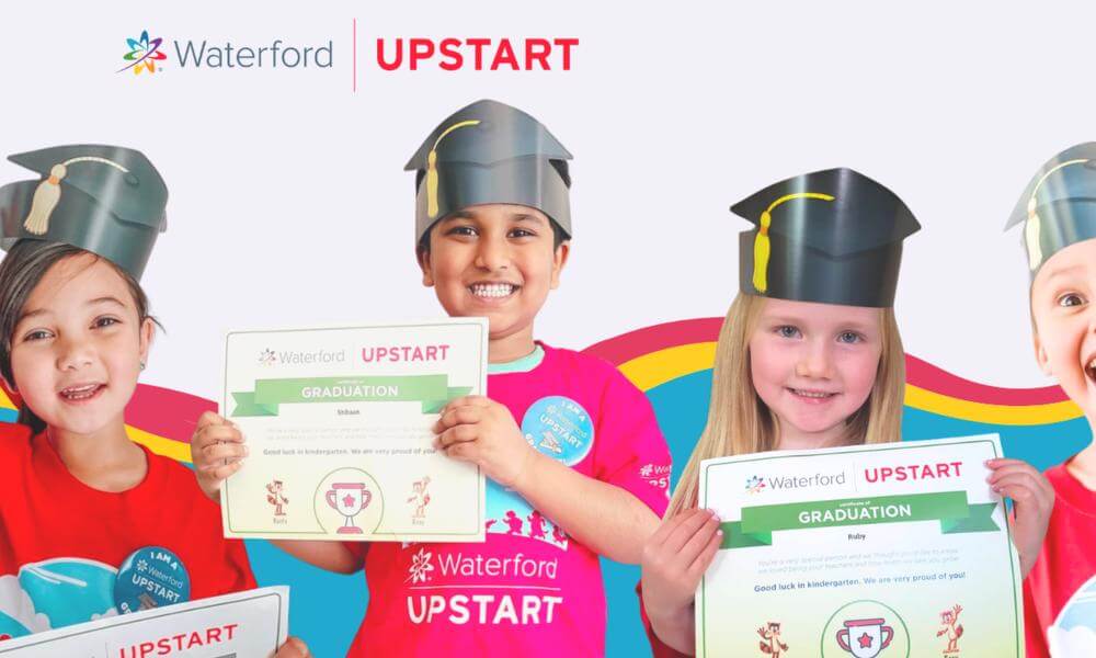 Four young children smiling holding Waterford Upstart graduation certificates