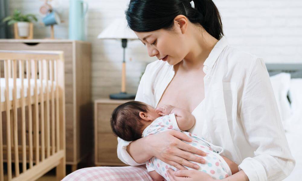 Woman looking down at baby while breastfeeding