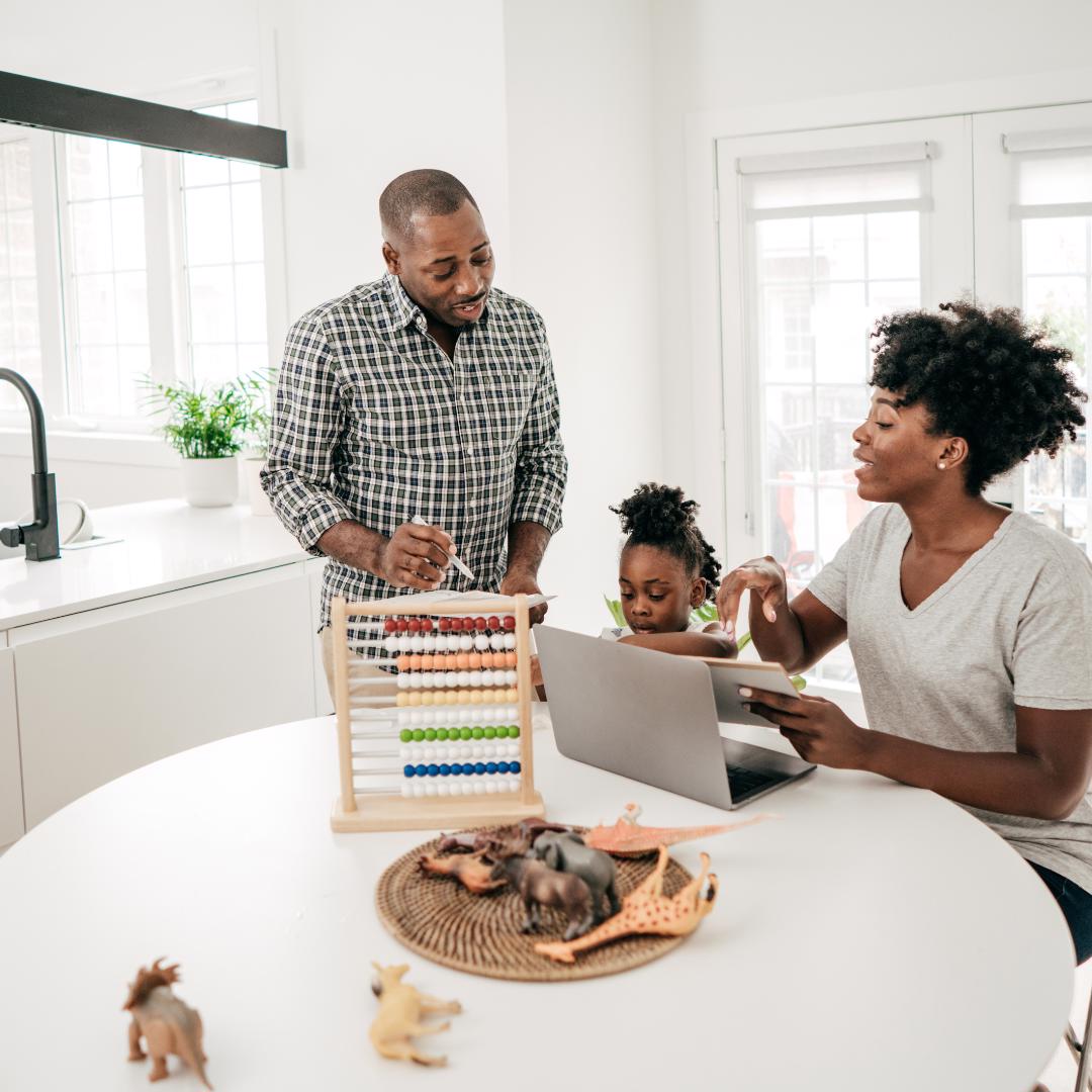 Family with laptop at the kitchen table