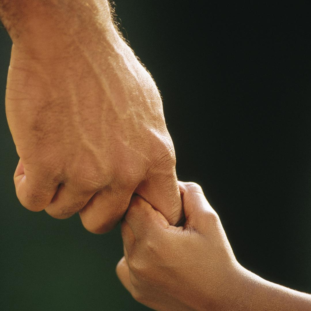 Adult holding child's hand