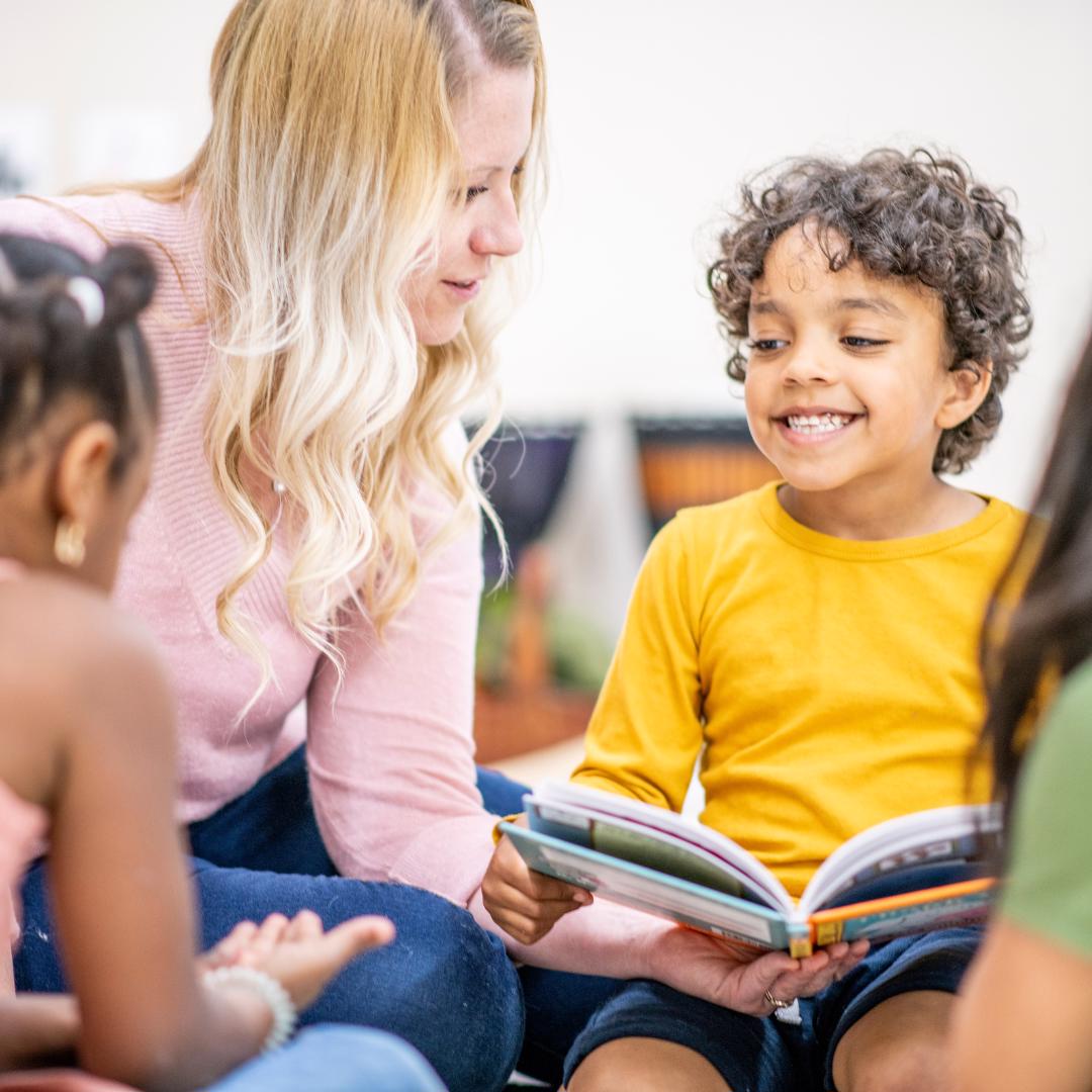 teacher with boy with book