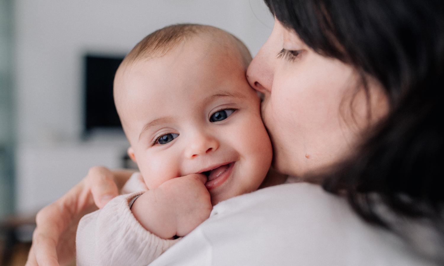 mom kissing baby on cheek