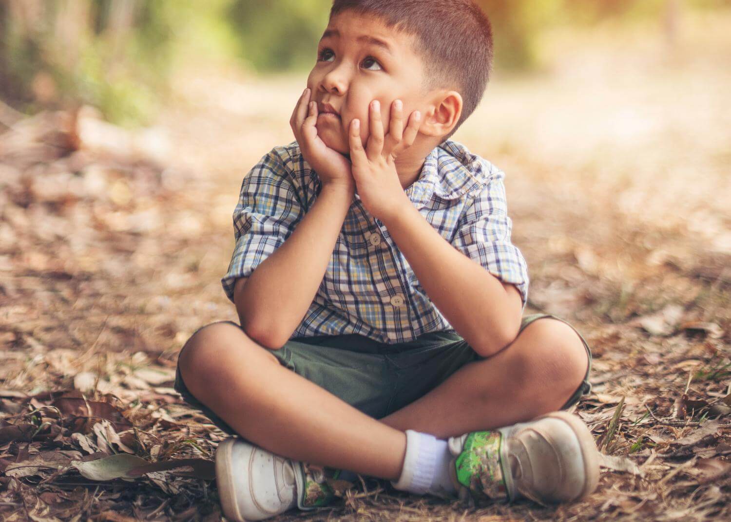 Young boy sitting crossed legged on the ground