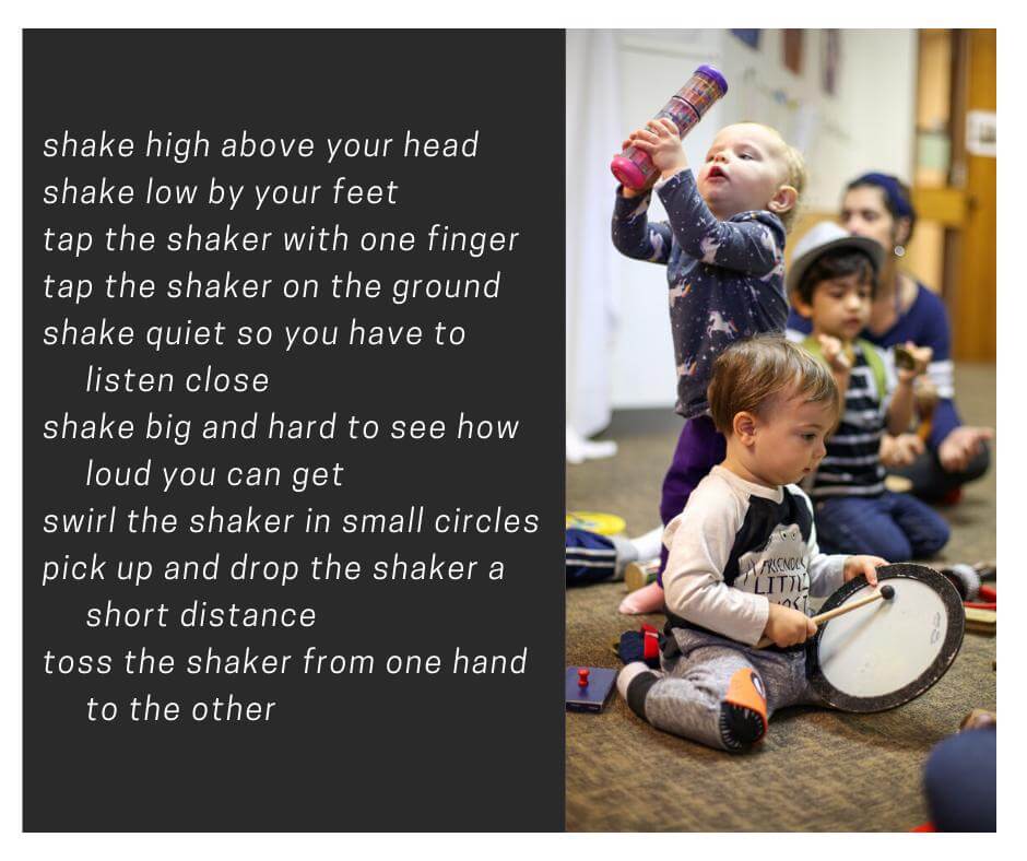 Two young children, one with a mallet and drum the other with a musical shaker held above his head