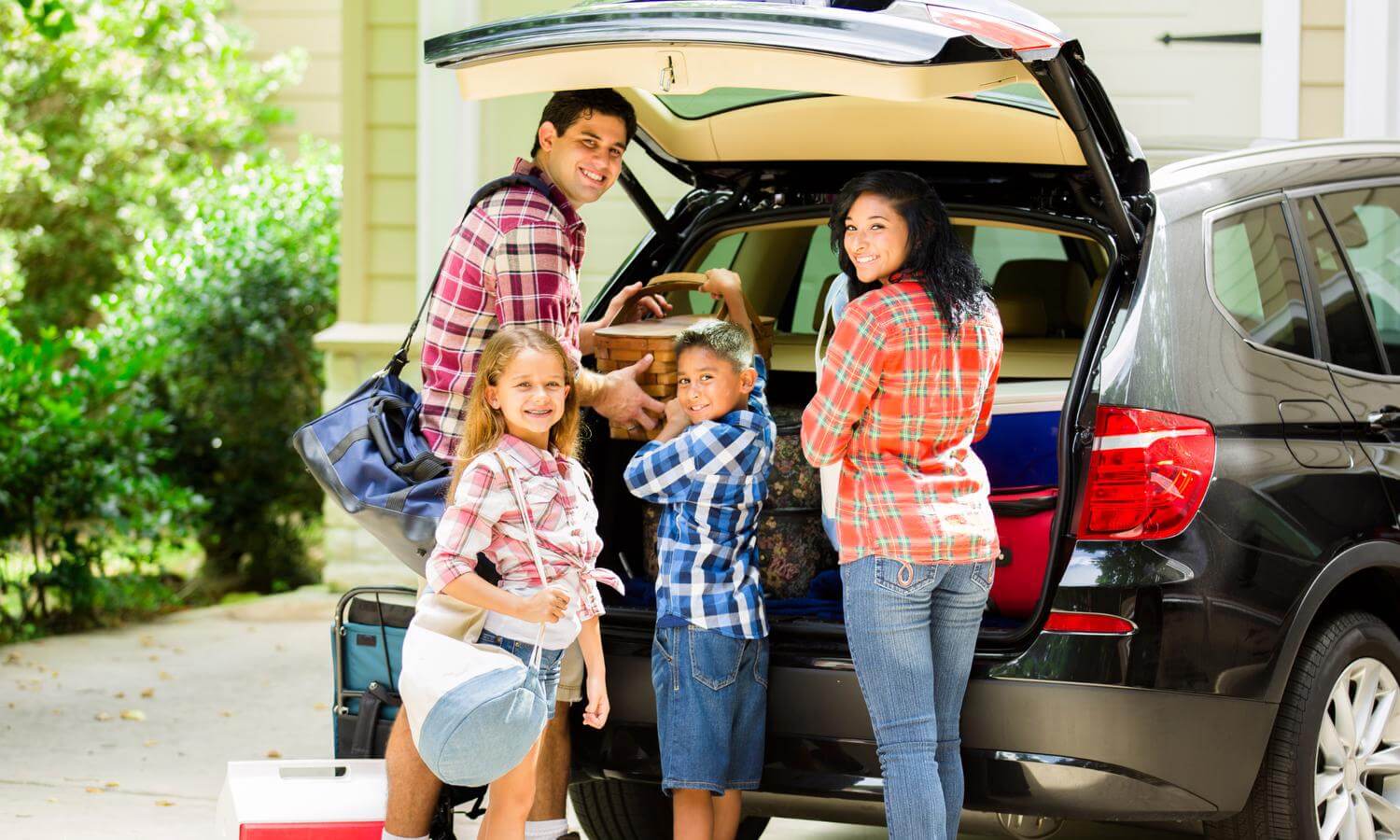 Family of four packs a car for a trip