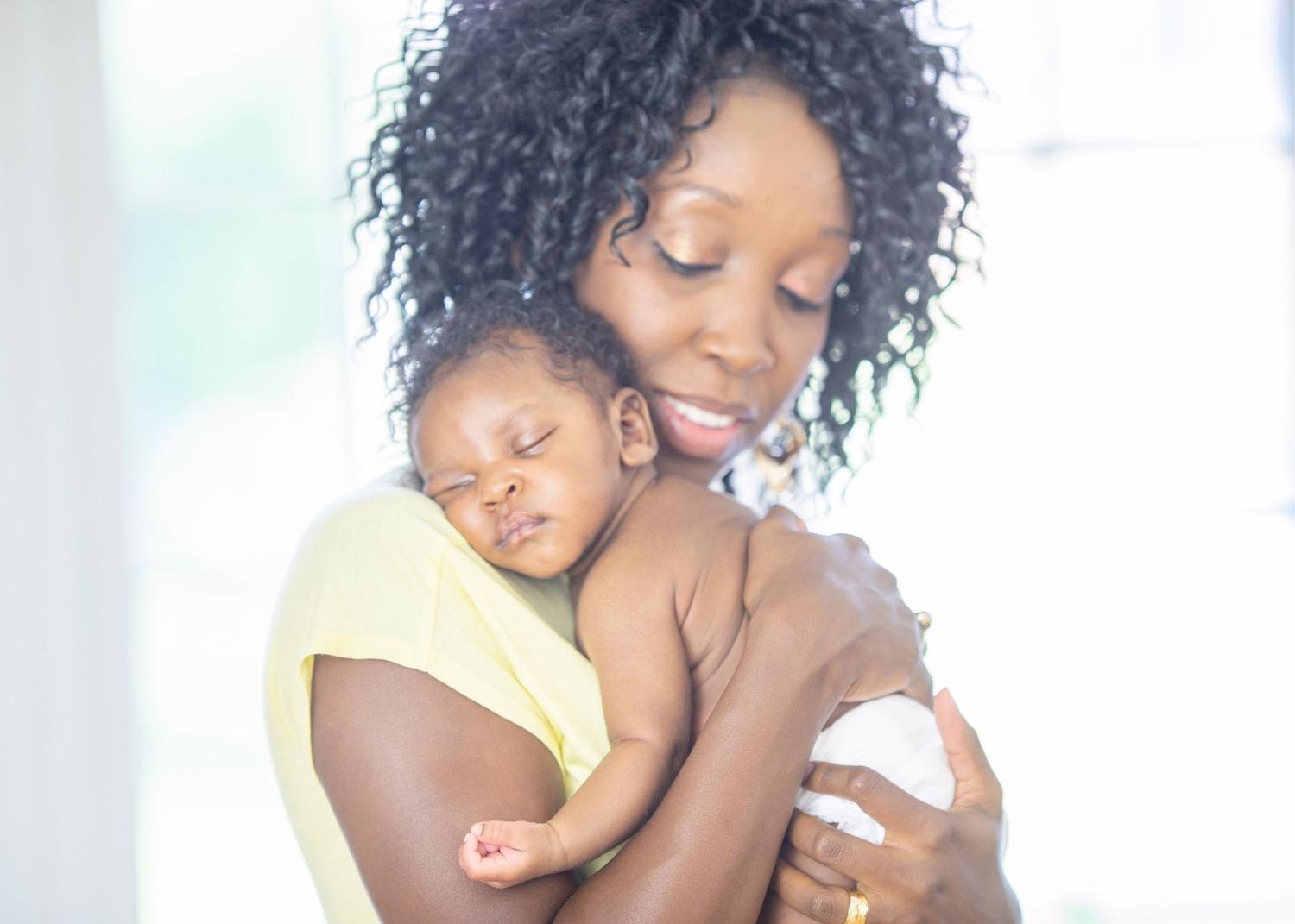 Black mother holding newborn black infant