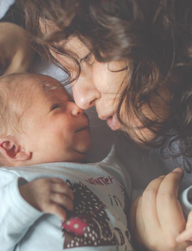 A woman cuddles a newborn baby.