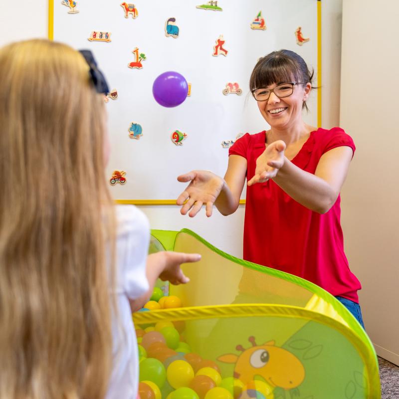 Occupational Therapist throwing ball to child
