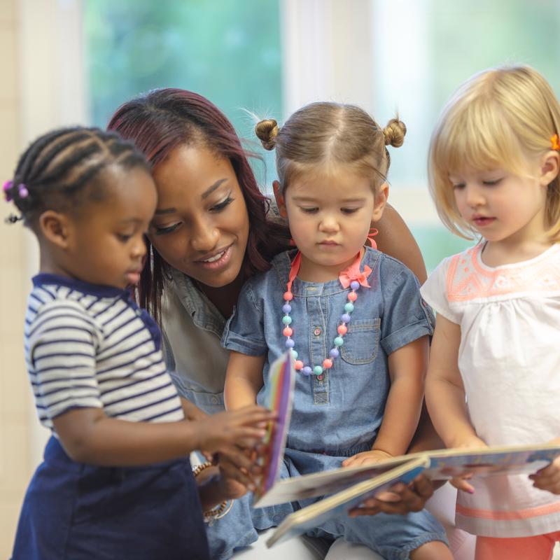 Adult reading to three young girls