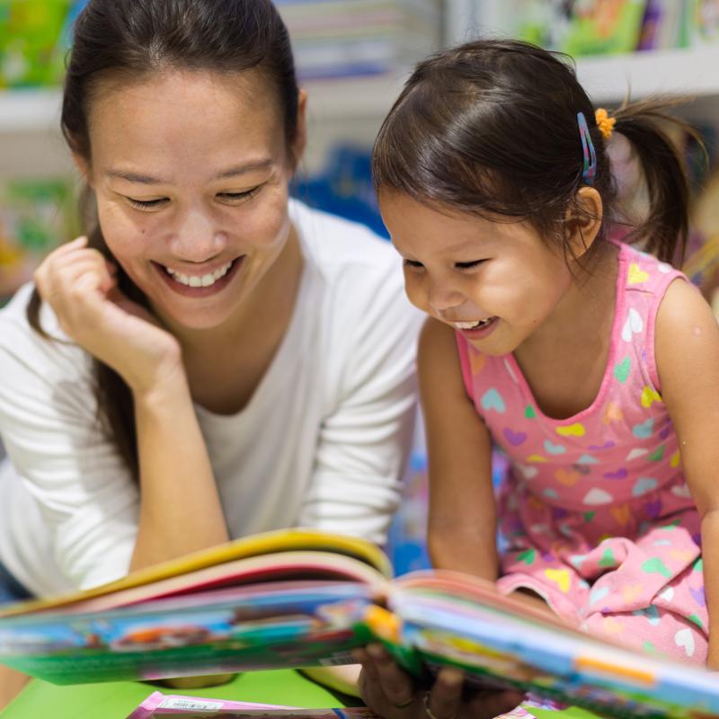 Mom reading book with daughter