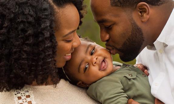 mom, dad and baby hugging