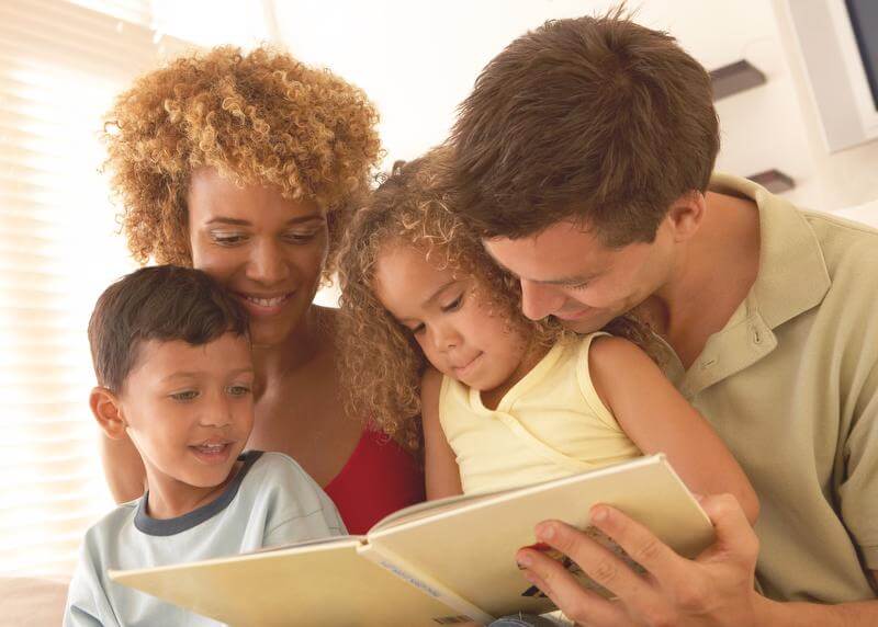 Woman and man reading to young boy and girl